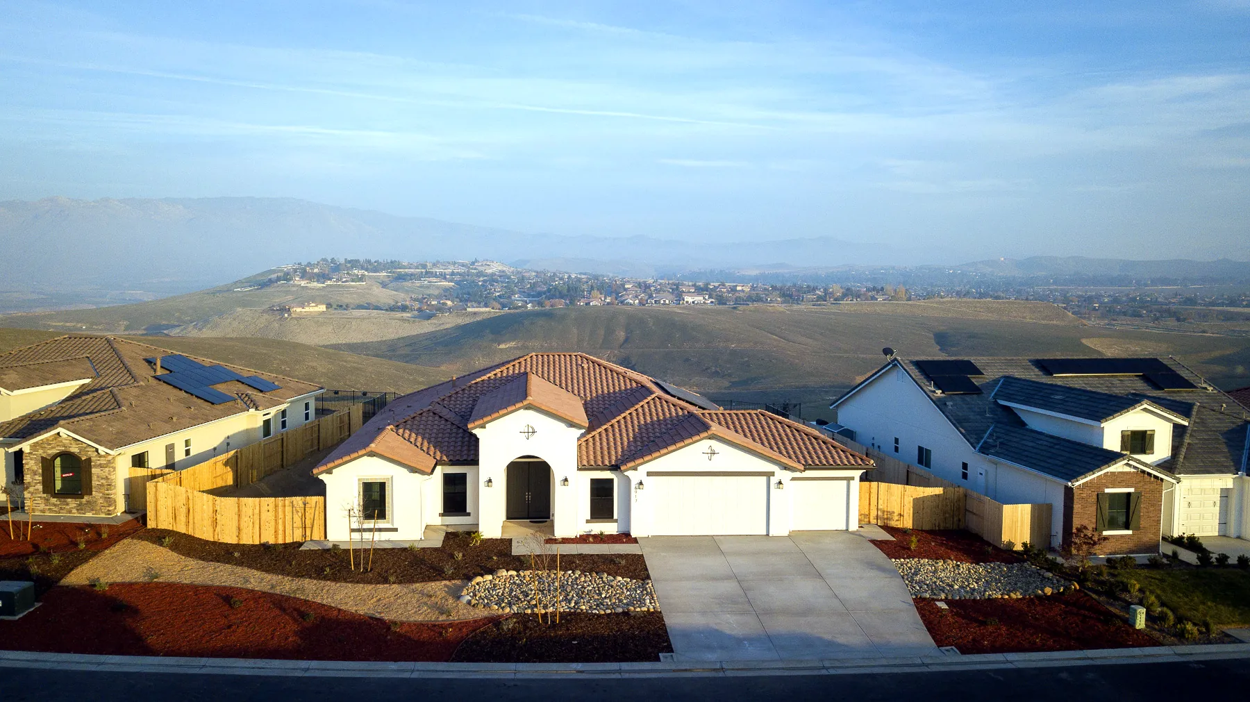 Aerial view of a Vista Montaire home on the hilltop, with the foothills behind it
