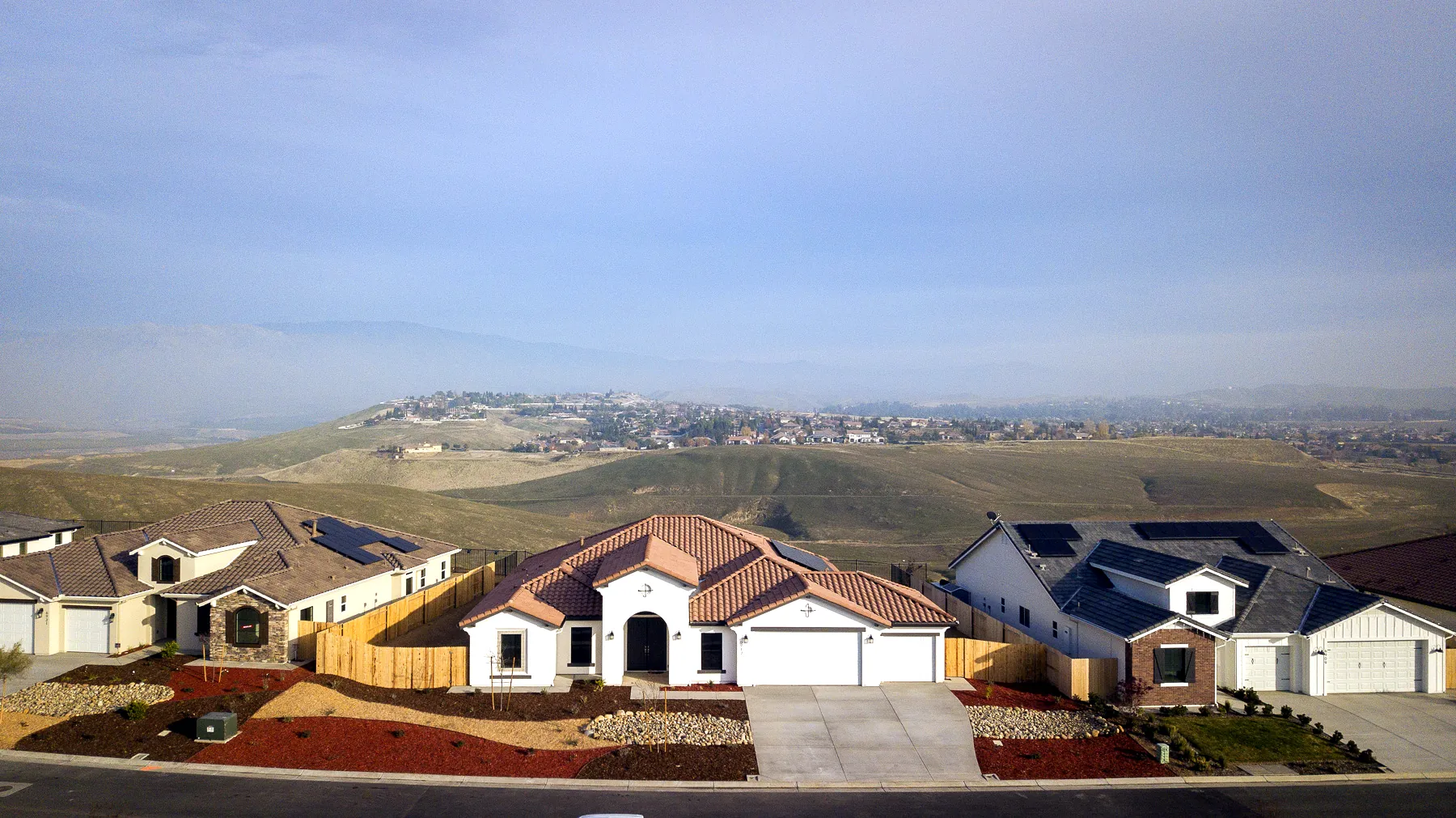 Aerial view of Vista Montaire homes on the hilltop, with rolling hills and northeast Bakersfield beyond