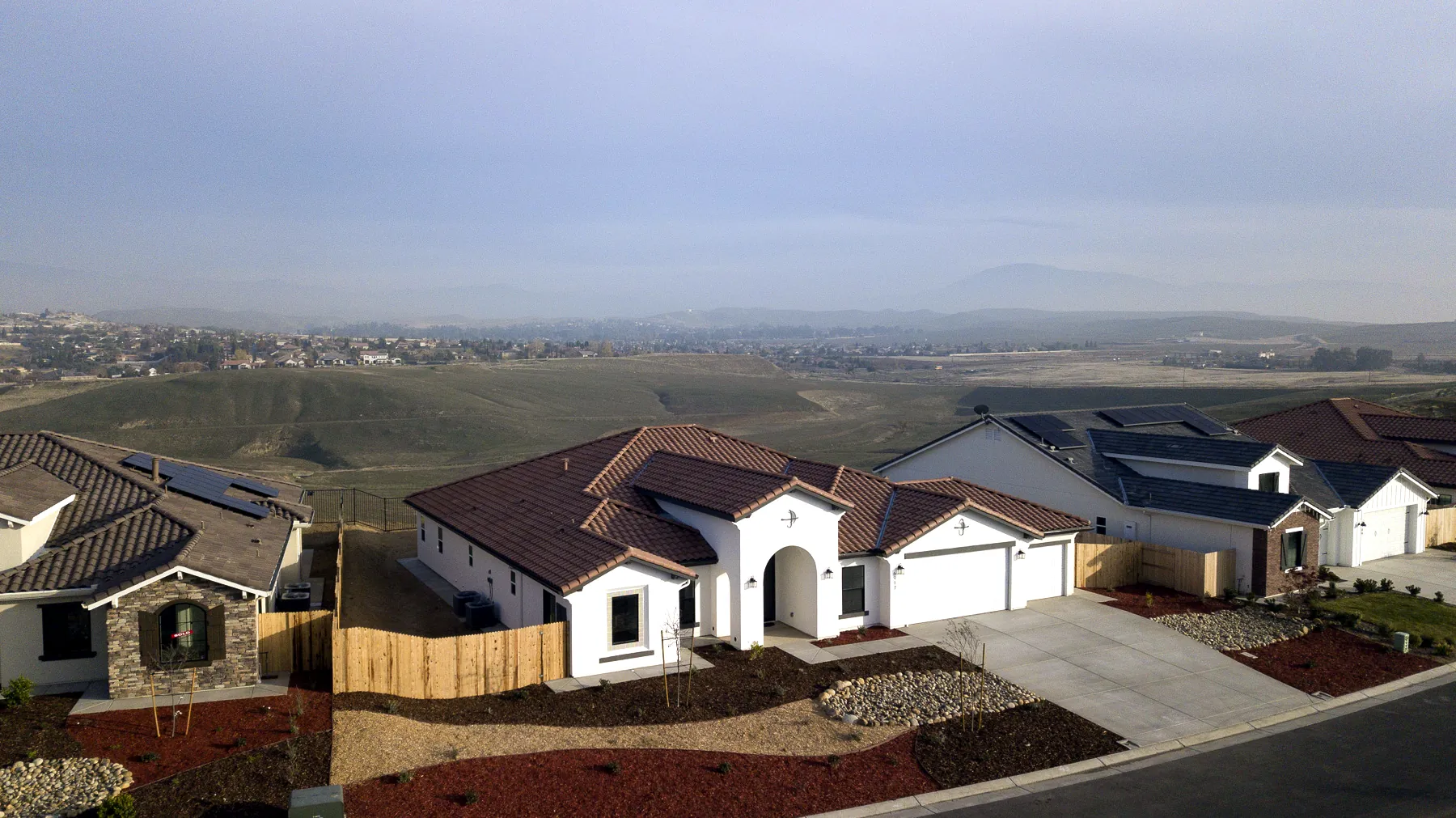 Aerial view of a single-story Spanish-style home at Vista Montaire, with the northeast Bakersfield foothills beyond